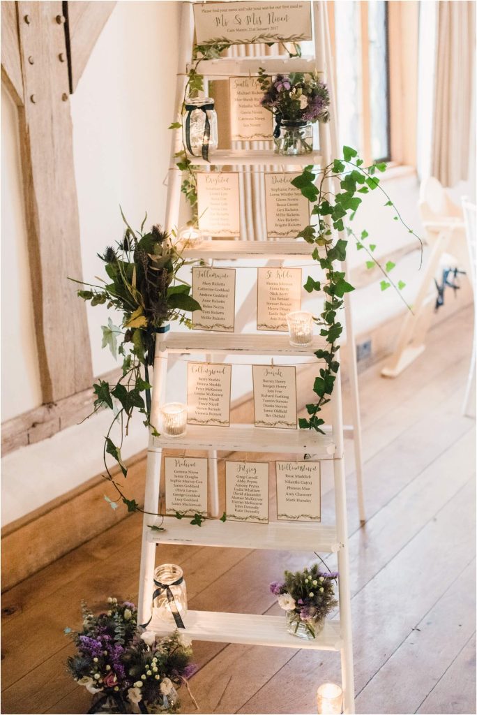 In questa foto un tableau di matrimonio in stile Shabby Chic creato con una scala di colore bianco a cui sono poggiati i cartoncini con i nomi degli ospiti