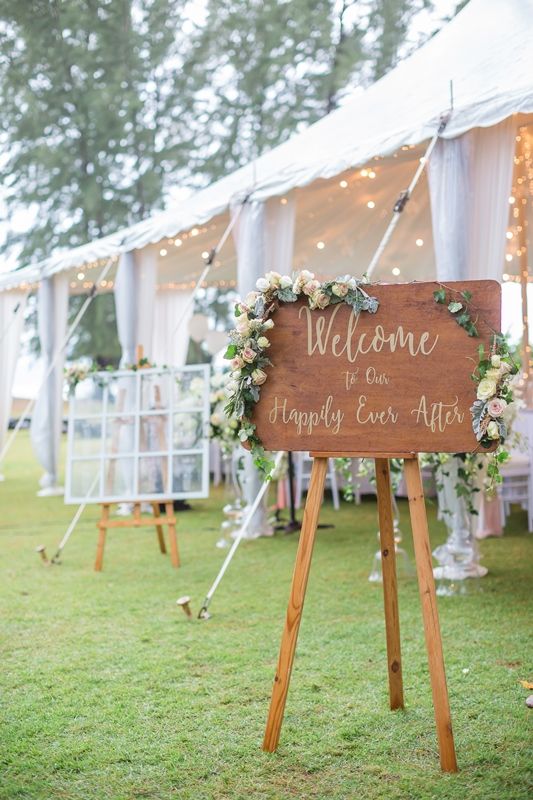 In questa foto un tableau welcome mariage di legno poggiato su un treppiedi 