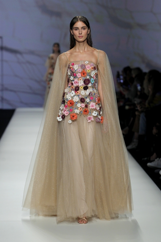 In questa foto la modella indossa un abito da sposa color carne con fiori tridimensionali multicolor.