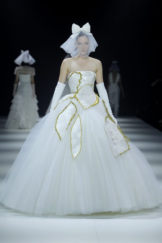 In questa foto la modella indossa un abito da sposa 2023 ampio in tulle con inserti oro.