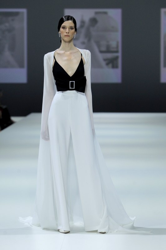 In questa foto la modella indossa un completo sposa con pantaloni bianchi e top nero di Nicole Milano.