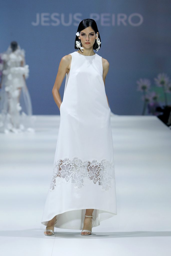 In questa foto la modella indossa un abito da sposa a campana con tasche e motivo floreale trasparente.