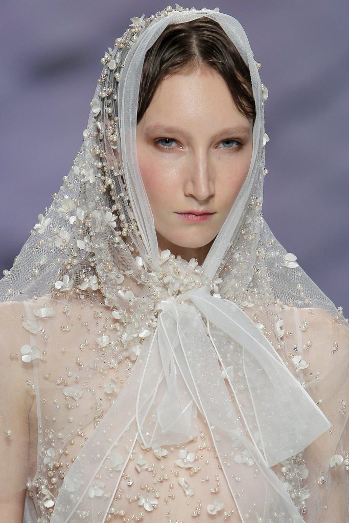 In questa foto la modella indossa un cappuccio da sposa trasparente con perline.
