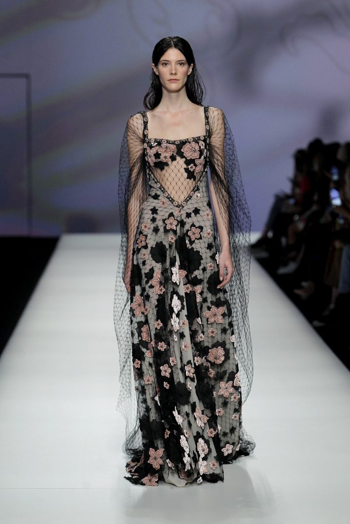 In questa foto la modella indossa un abito da sposa colorato 2023 con retina nera e fiori rosa.