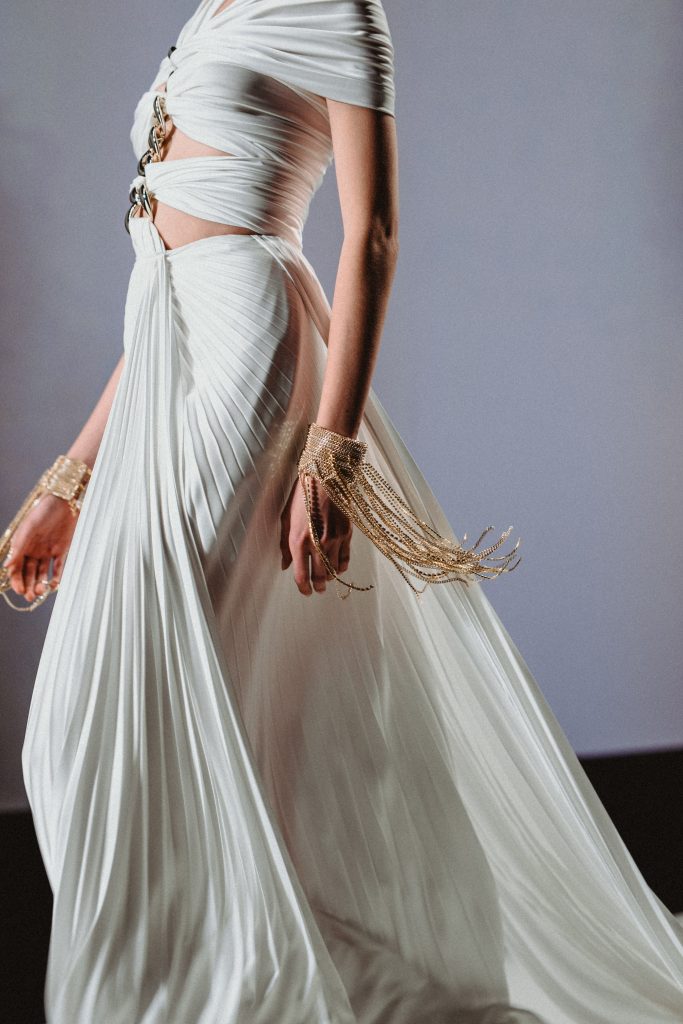 In questa foto la modella indossa un abito da sposa con tagli centrali e gonna plissettata.