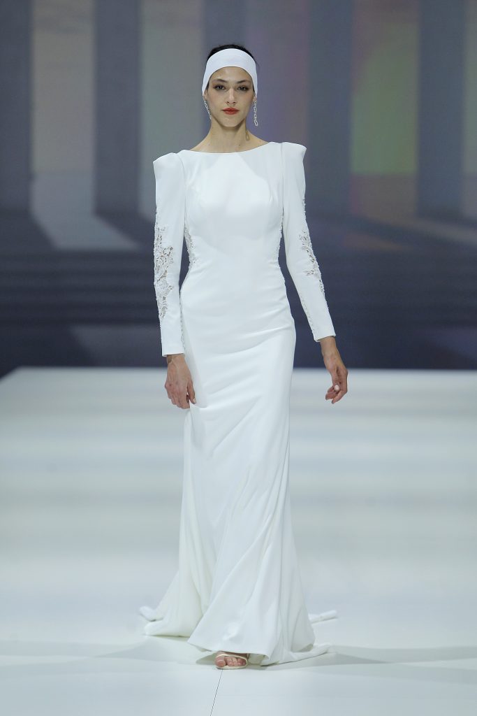 In questa foto la modella indossa un abito da sposa con tessuto particolare Higar Novias 2023 a maniche lunghe.