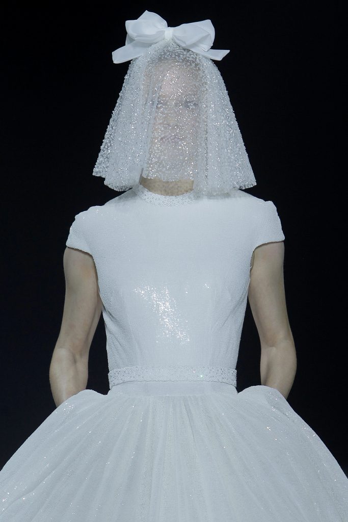 In questa foto la modella indossa uno degli abiti da sposa particolari 2023 con tessuto paillettato total white.