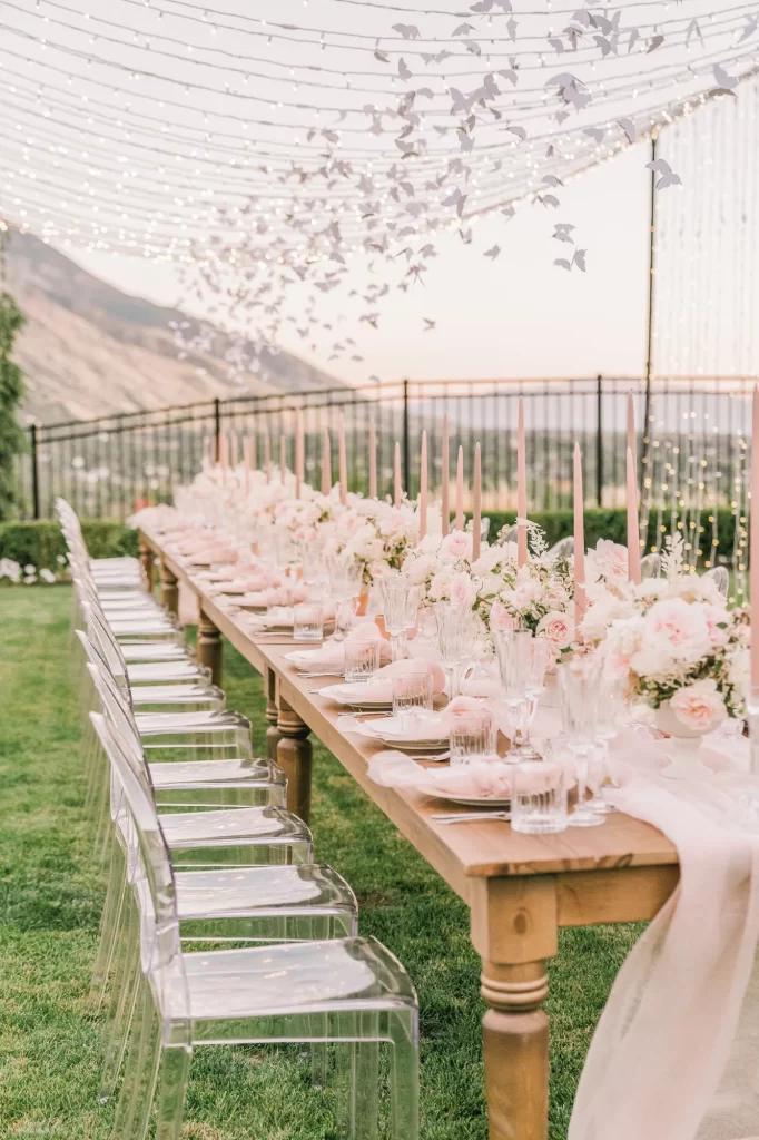 In questa foto un'idea di tavolo matrimonio imperiale decorato con runner di stoffa colore rosa, candele, fiori e tovagliolo abbinati