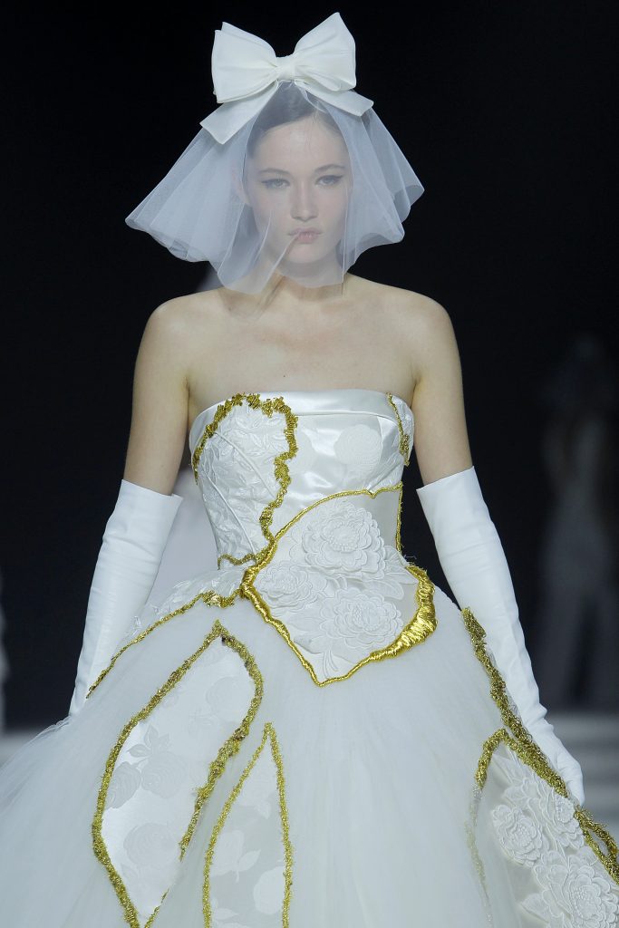 In questa foto la modella indossa un abito da sposa con dettagli di patchwork color oro.