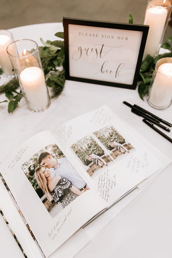 In questa foto un'idea di guestbook per matrimonio: un libro con foto e messaggi per gli sposi posizionato su un tavolo decorato con candele e foglie