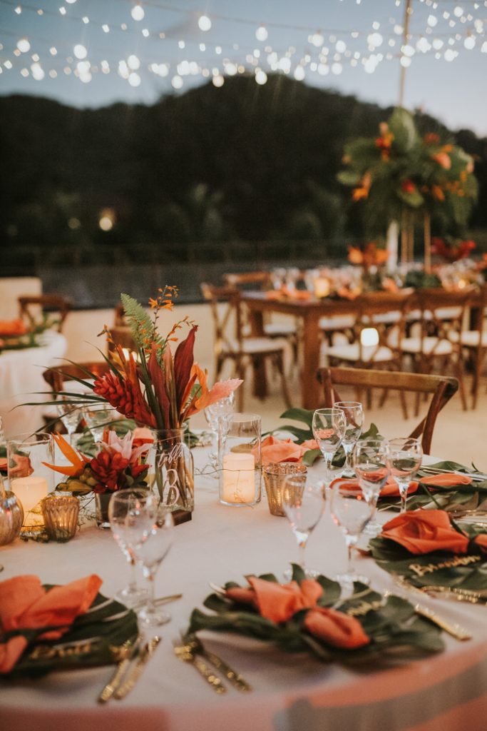 In questa foto un'idea di tavolo matrimonio in stile tropicale nei toni del rosso, dell'arancione e del verde
