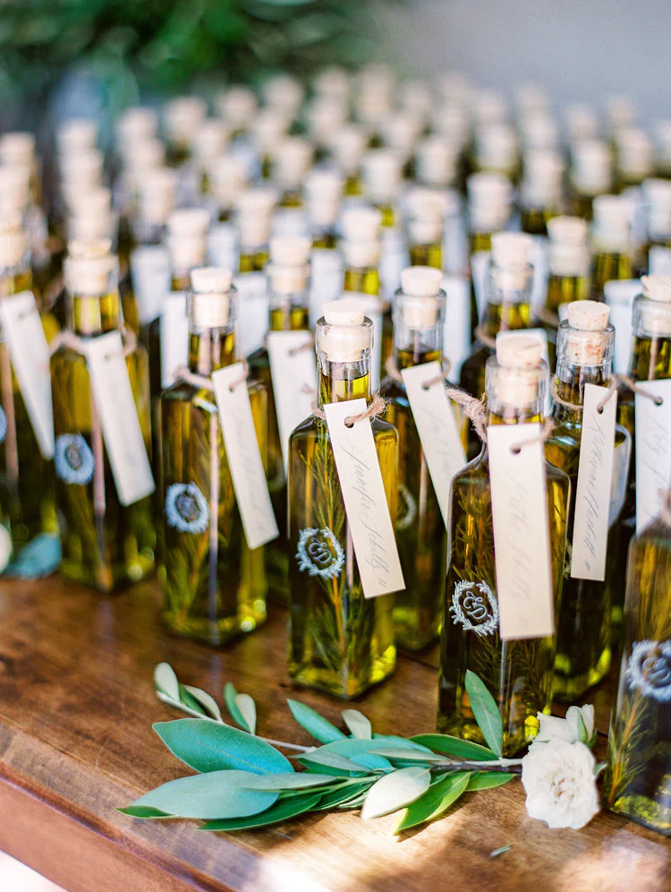 In questa foto un'idea di bomboniere per matrimonio country chic con piccole bottiglie di olio e rosmarino