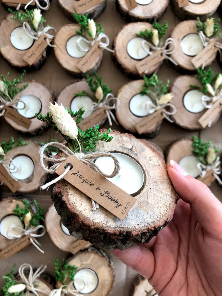 In questa foto un'idea di bomboniere matrimonio a tema green con candele incastonate in piccoli cerchi di legno e foglie