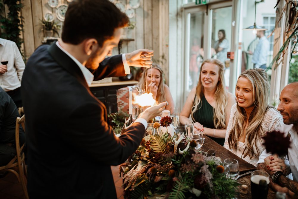 In questa foto idee per matrimonio intrattenimento: spettacolo di un mago davanti agli sposi e ad alcune invitate