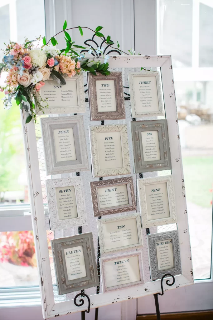 In questa foto un'idea di tableau mariage shabby chic cornici con le card degli ospiti raccolte in una cornice di legno bianca 