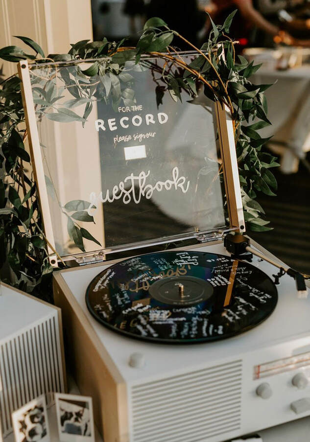 In questa foto un'idea di guestbook matrimonio a tema musica. Le firme degli ospiti sono su un disco di vinile sistemato su un giradischi