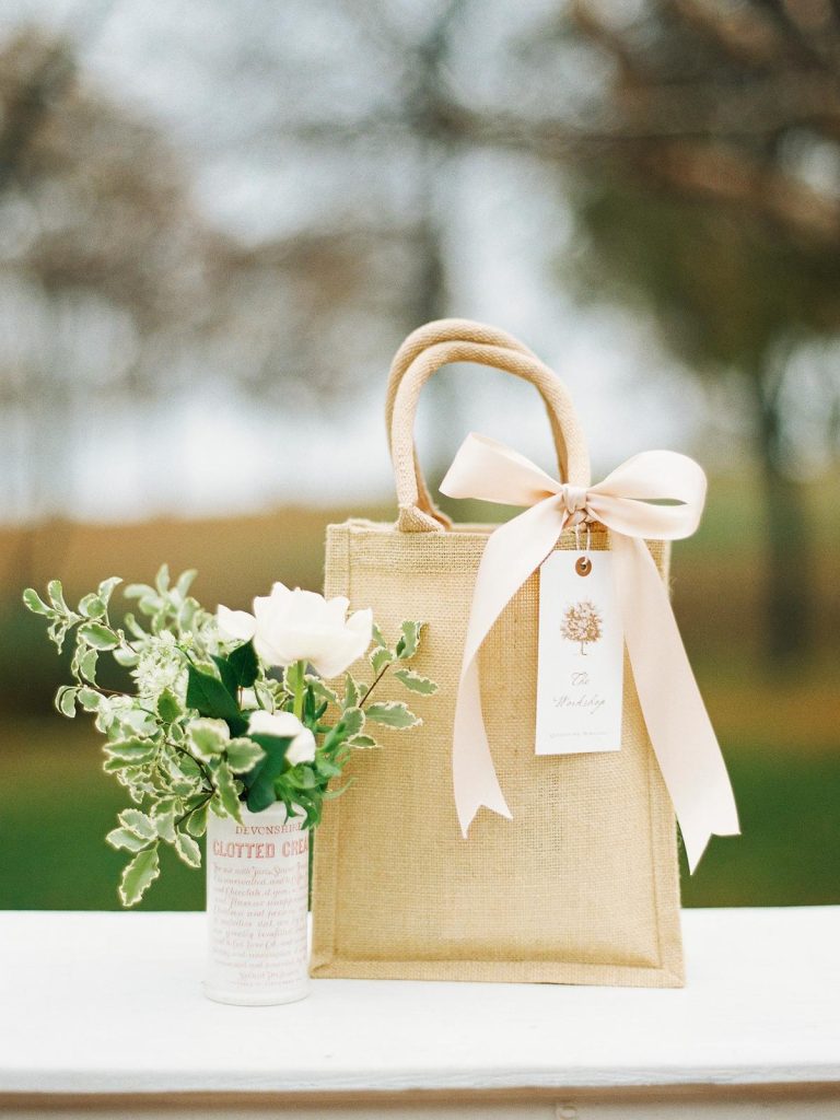 In questa foto un'idea di wedding bag: una borsa in iuta chiusa da un fiocco colore rosa tenue e un tag abbinato