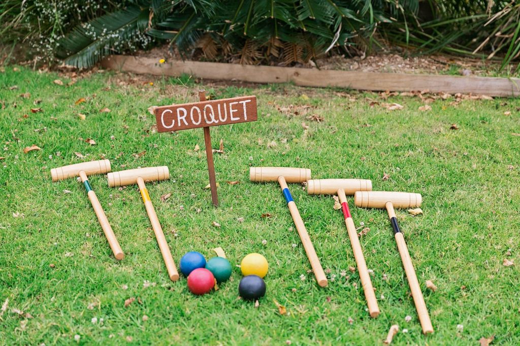 In questa foto aste e palline di legno per il croquet poggiati su un prato