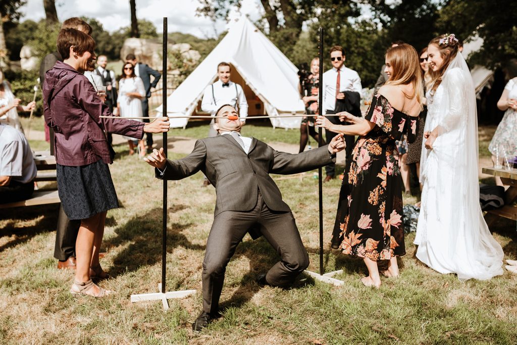 In questa foto l'invitato di un matrimonio gioca al limbo mentre altri invitati guardano