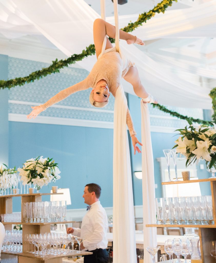 In questa foto una trapezista appesa per un nastro sul soffitto della sala di un ricevimento del matrimonio