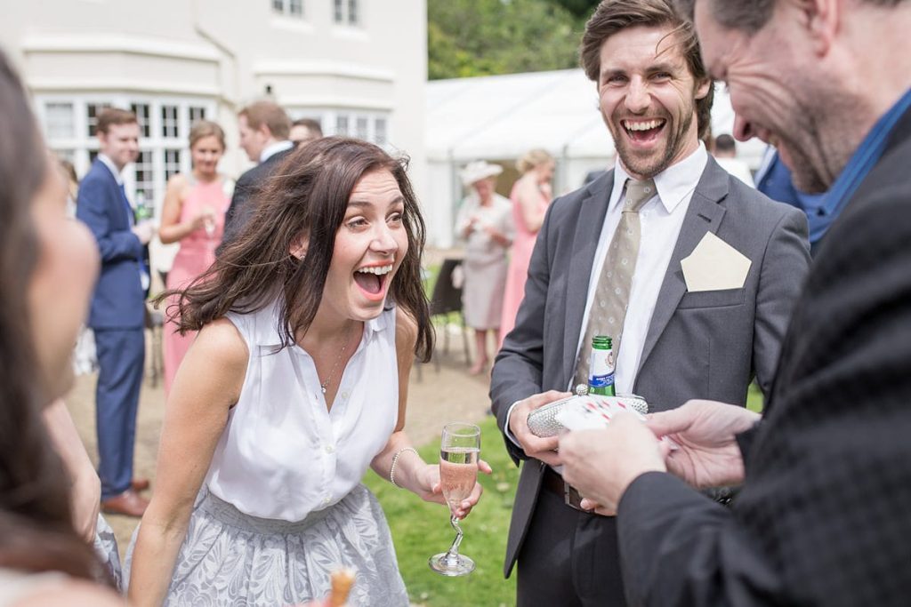 In questa l'invitata di un matrimonio ride stupita al trucco di un mago