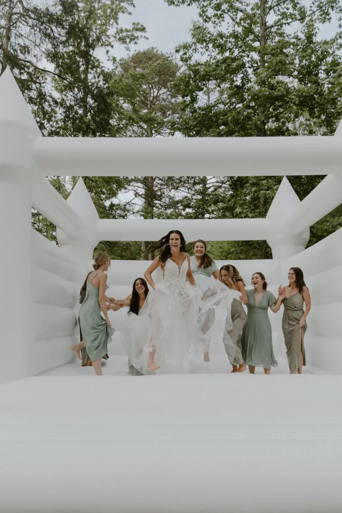 In questa foto una sposa e le sue damigelle saltano su un gonfiabile