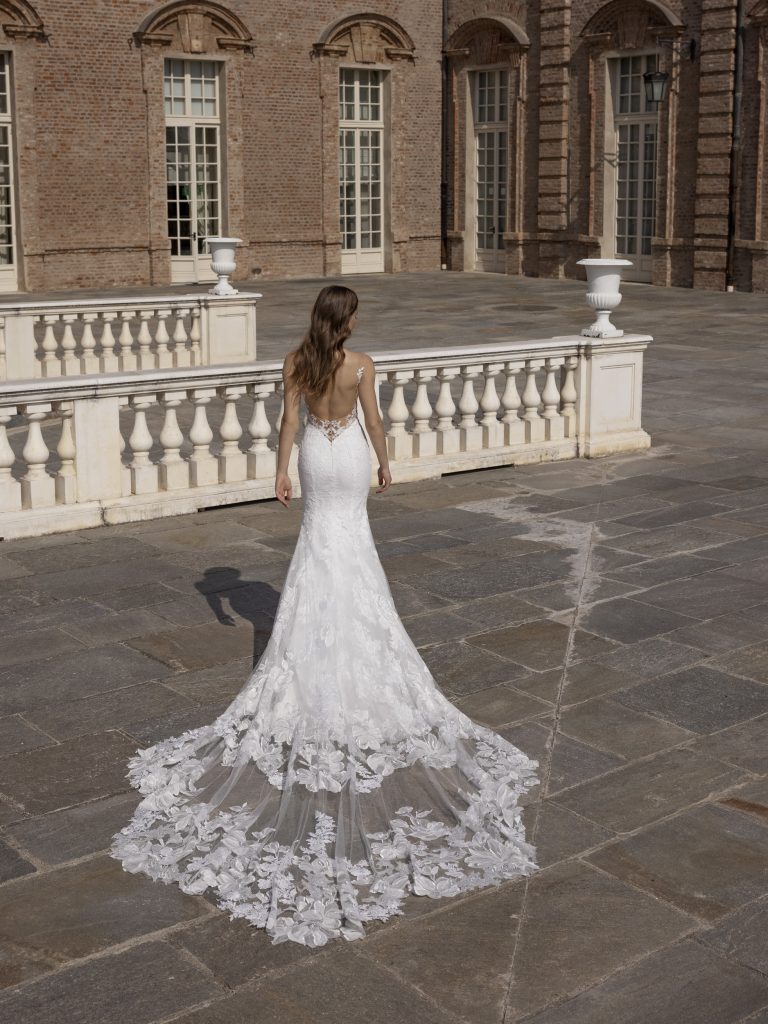 In questa foto un abito da sposa a sirena della Maison italiana con strascico in pizzo ricamato 