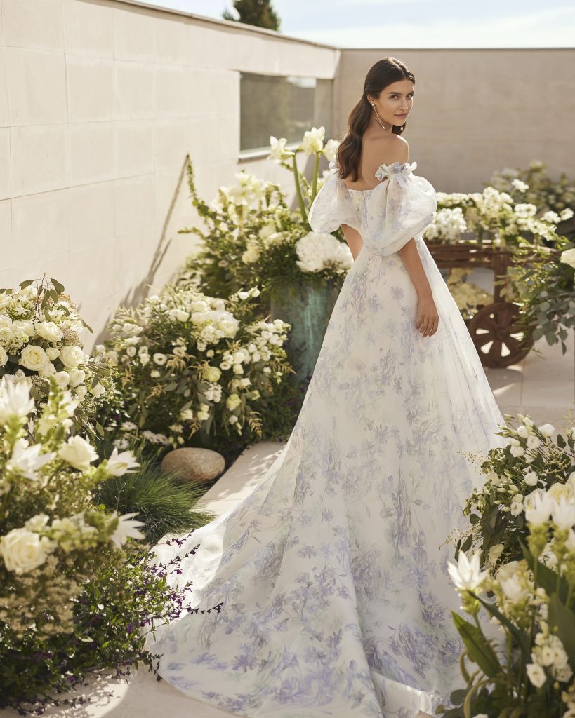 In questa immagine un modello con decorazioni floreali color malva della collezione di abiti da sposa Rosa Clará Couture 2023.