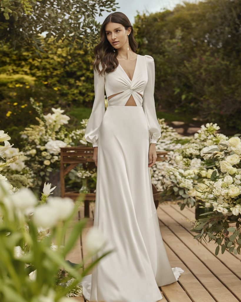 In questa foto la modella indossa un abito da sposa scivolato con maniche lunghe e dettaglio cut out Rosa Clarà
