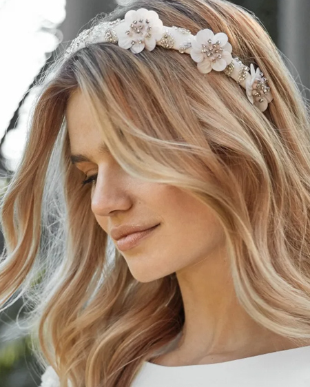 In questa foto la modella indossa un cerchietto con fiori e perline di Pronovias.