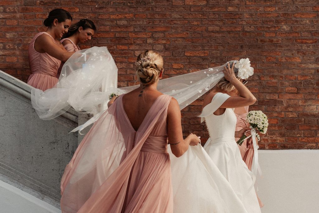 In questa foto Federica Pellegrini e le sue damigelle, che le tengono il velo nel giorno del suo matrimonio