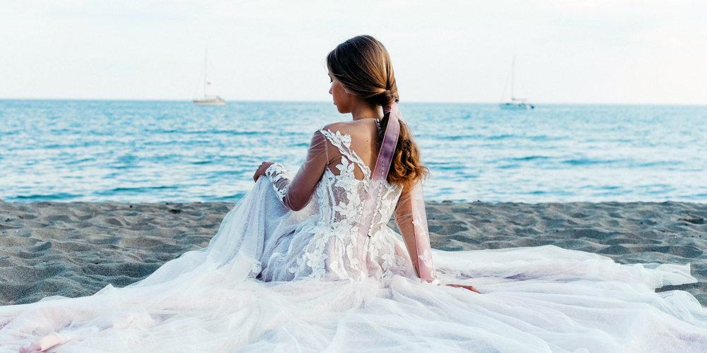 In questa foto una sposa in riva al mare fotografata di spalle