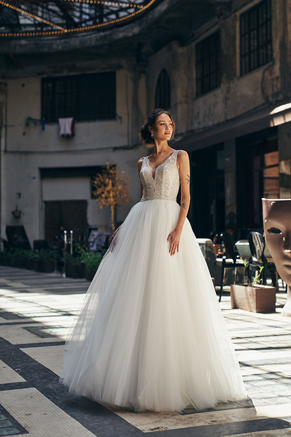 In questa foto una modella indossa uno degli abiti da sposa Annais Bridal 2023 modello principessa con gonna in tulle e corpetto con cristalli