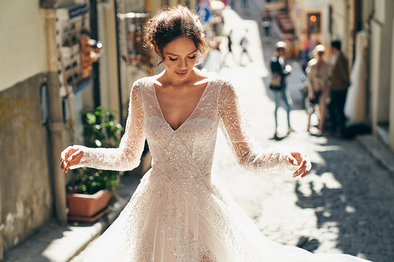 In questa foto una modella indossa un abito da sposa Annais Bridal 2023 con applicazioni sparkling su tessuto
