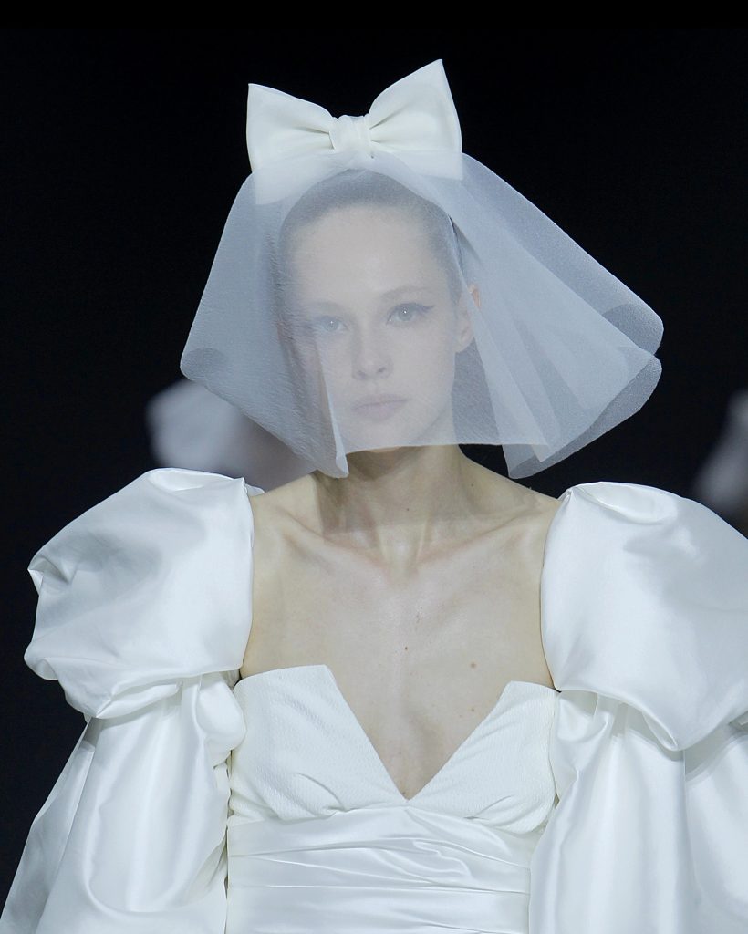 In questa foto una modella indossa un velo da sposa con maxi fiocco.
