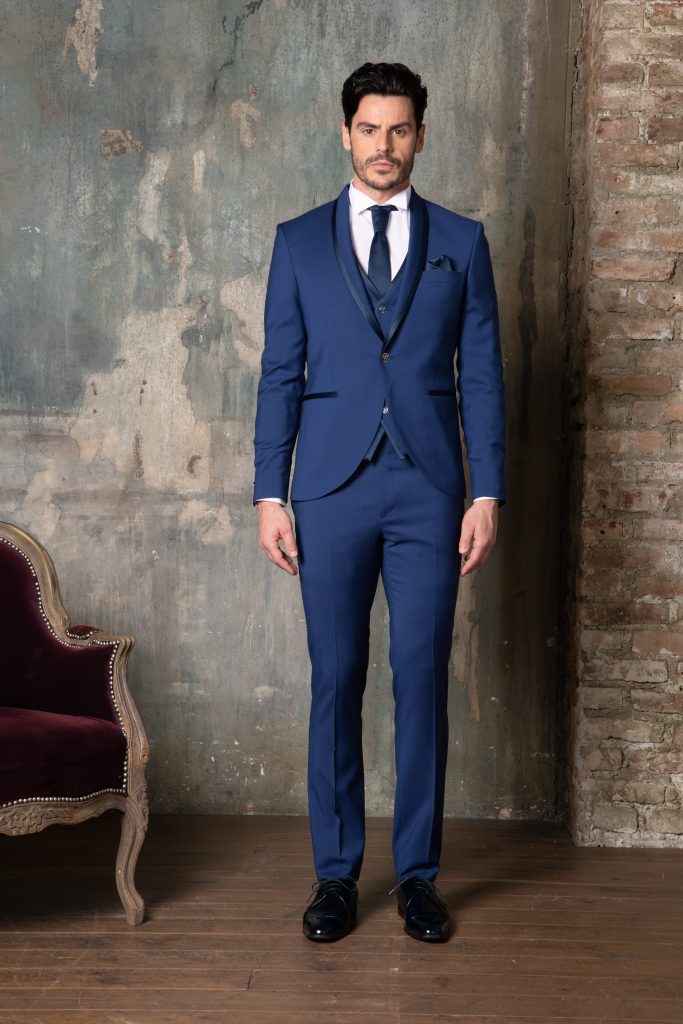 In questa foto un modello indossa un abito da sposo classico di colore blu di Luigi Convertini