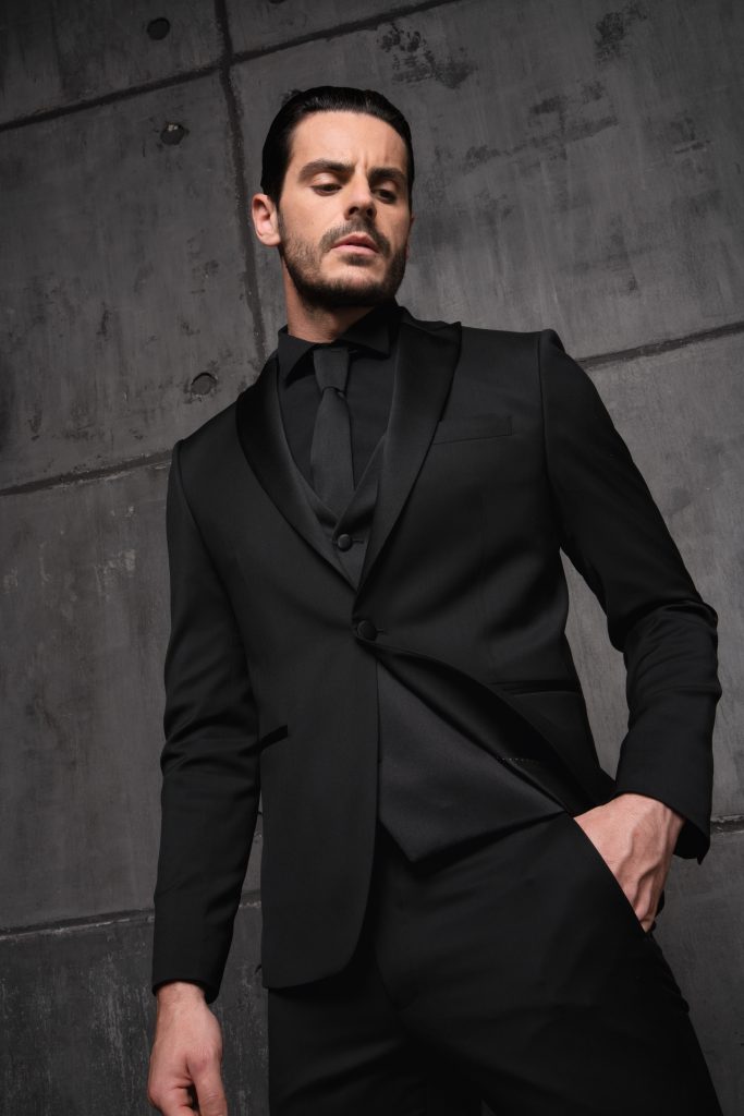 In questa foto un modello indossa un abito da sposo di colore nero di Luigi Convertini