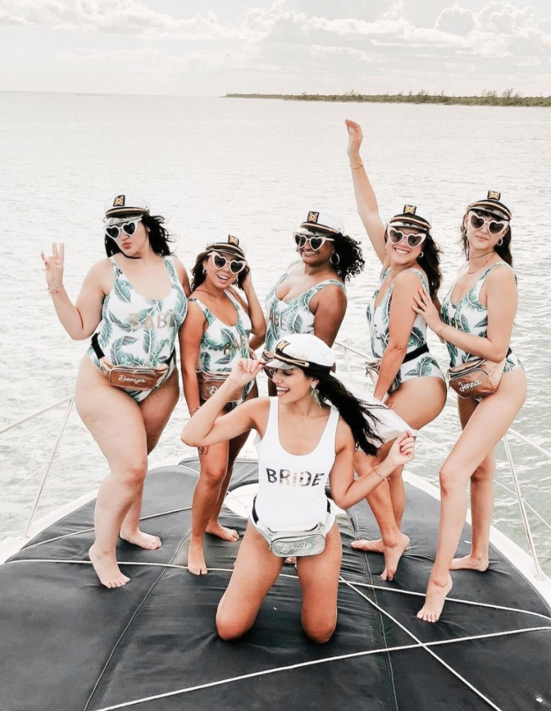 In questa foto 6 ragazze festeggiano un addio al nubilato in barca con costumi e cappelli coordinati