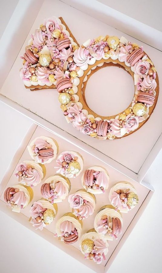 In questa foto una torta er addio al nubilato a forma di anello con cupcakes abbinati nei toni del rosa e del giallo