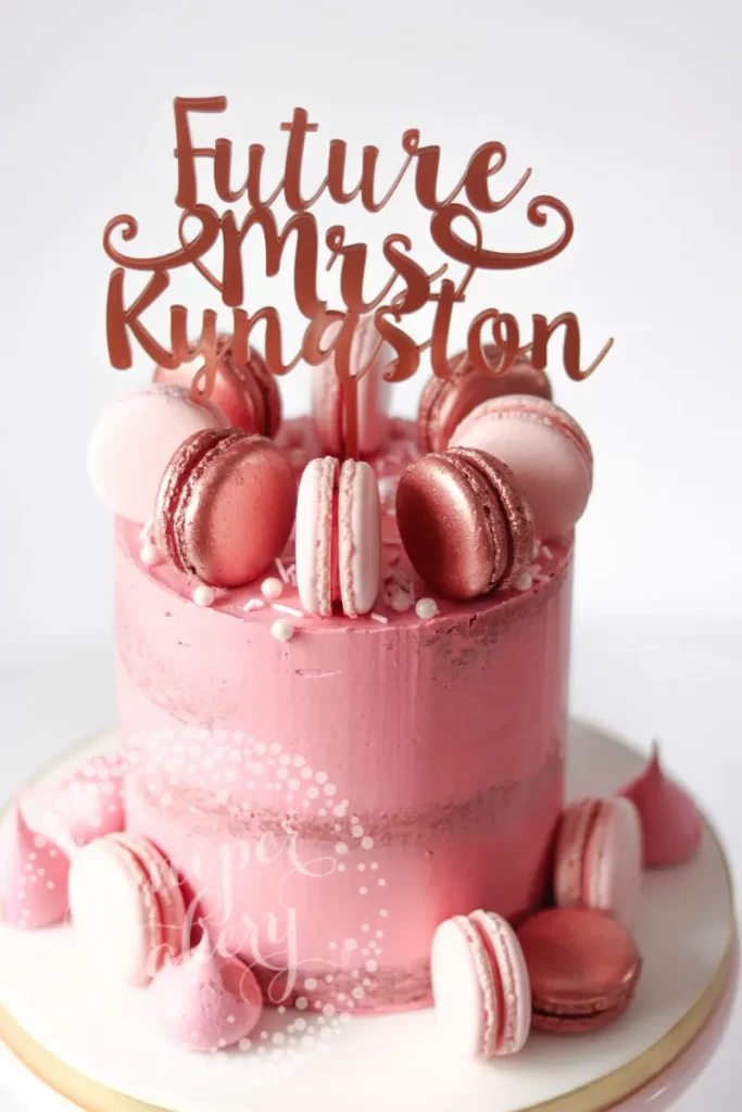 In questa foto una torta dipinta con macarons con cake topper con scritto Bride to be