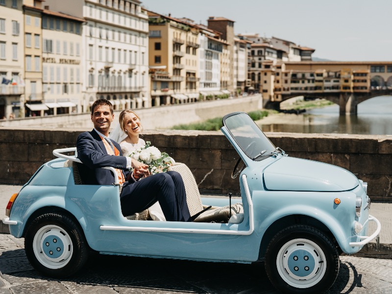 in questa foto una coppia di sposi in una Cinquecento d'epoc su Ponte Vecchio, Firenze