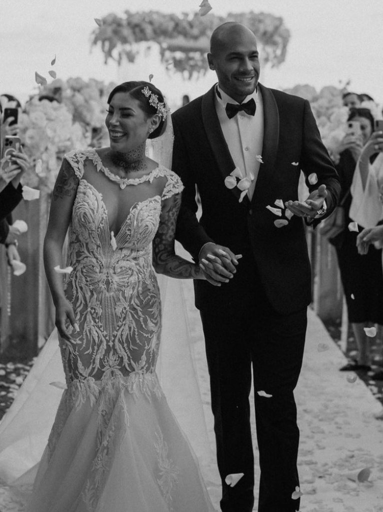 In questa foto Marcell Jacobs e Nicole Daza percorrono sorridenti la navata dopo essersi scambiati le promesse durante il loro matrimonio