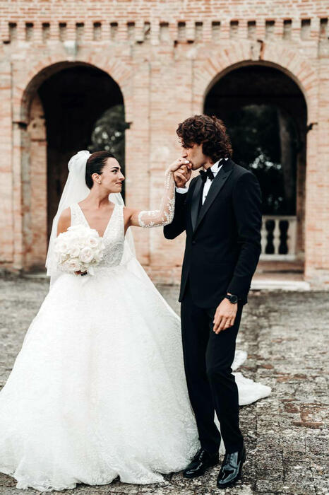 In questa foto gli sposi in uno dei cortili di Villa Imperiale: Gianmarco Tamberi bacia la mano a Chiara Bontempi.