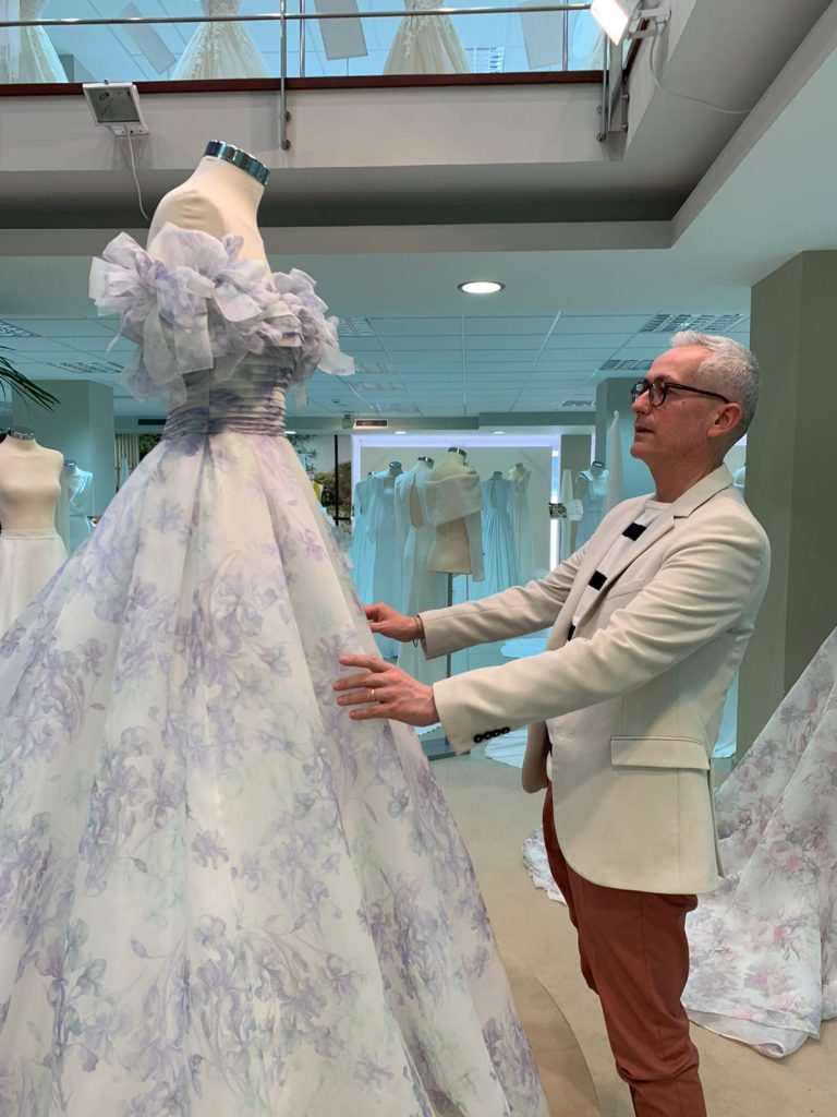 In questa foto un particolare abito da sposa nell'atelier di Alfio Polisano: bianco e lilla con gonna ampia e maniche corte e gonfie