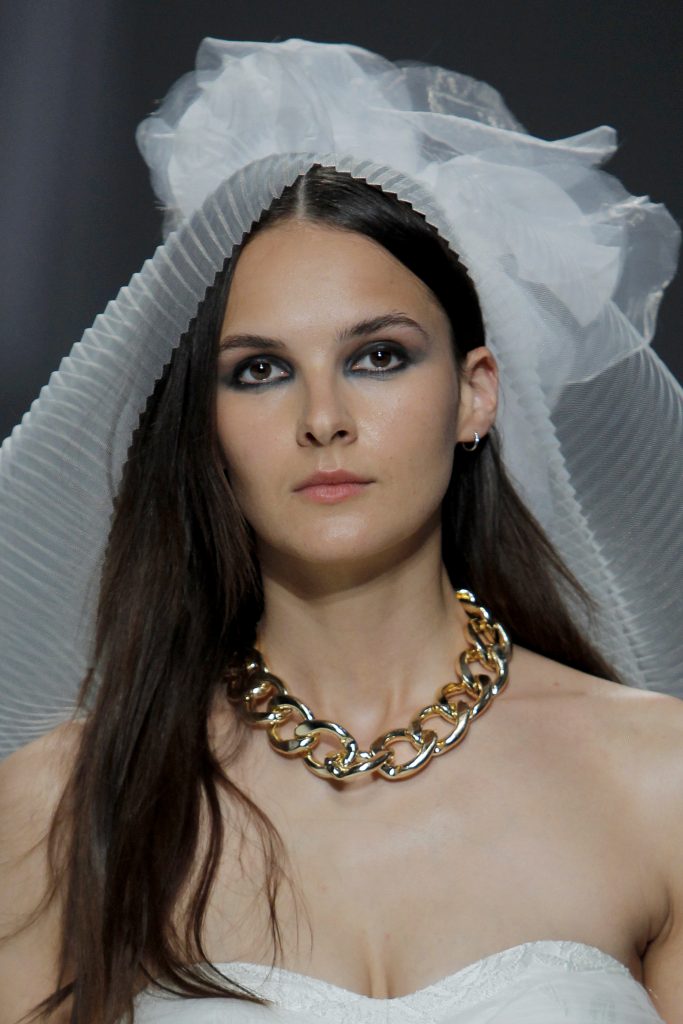 In questa foto una modella indossa una catena d'oro con l'abito da sposa.