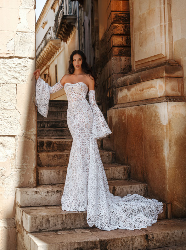 In questa foto una modella con un abito da sposa a sirena in pizzo all over della collezione Claudio Di Mari 2023