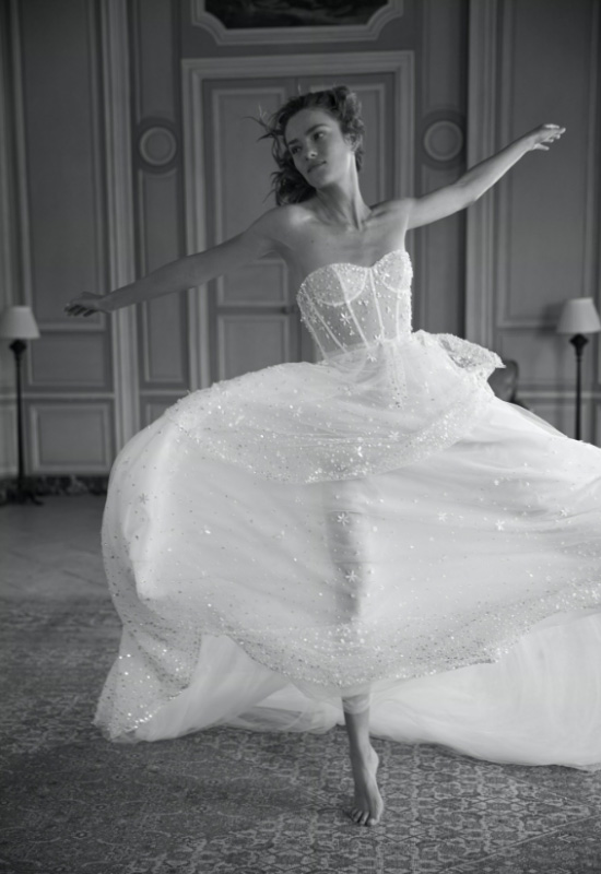 In questa foto una modella danza indossando un abito da sposa con stelline di Eisen Stein 2023