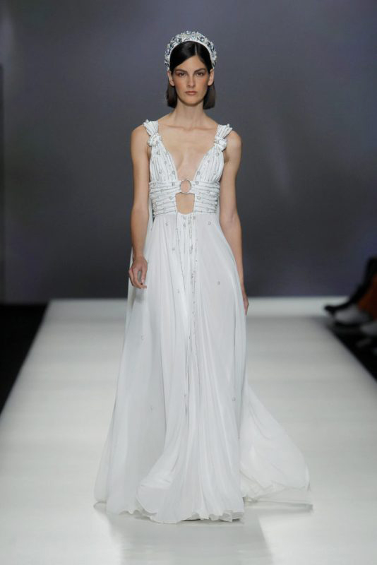 In questa foto una modella in passerella sfila con uno degli abiti da sposa 2023 della collezione Isabel Sanchis
