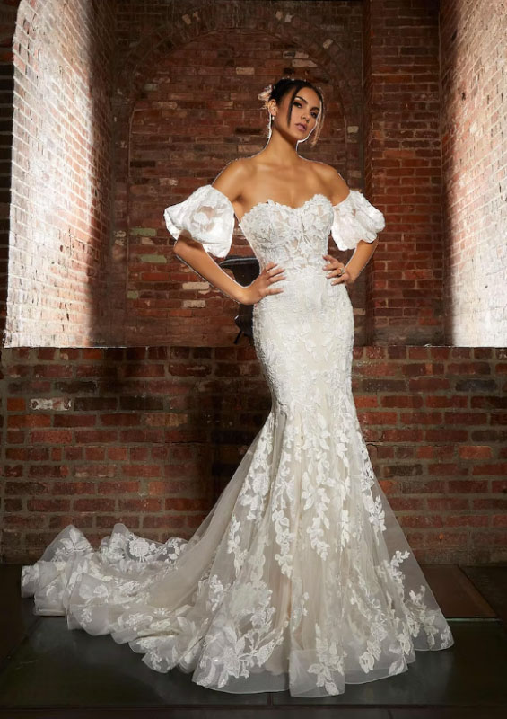 In questa foto la modella posa con un abito da sposa della collezione Madeline Gardner Signature 2023