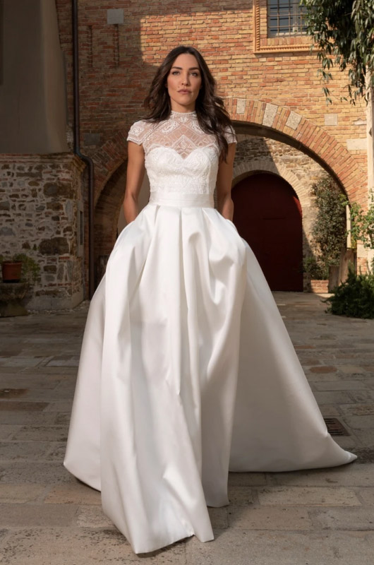 In questa foto una modella indossa con un abito da sposa della collezione Michele Gritti 2023